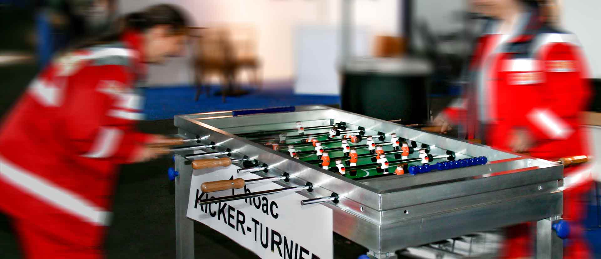 Two employees play against each other on a table football table