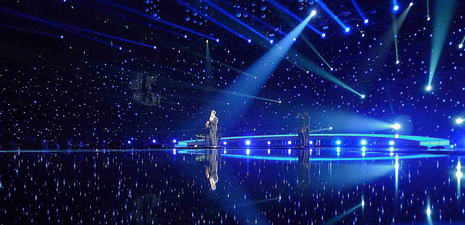 Someone performs on a mobile stage with blue lights