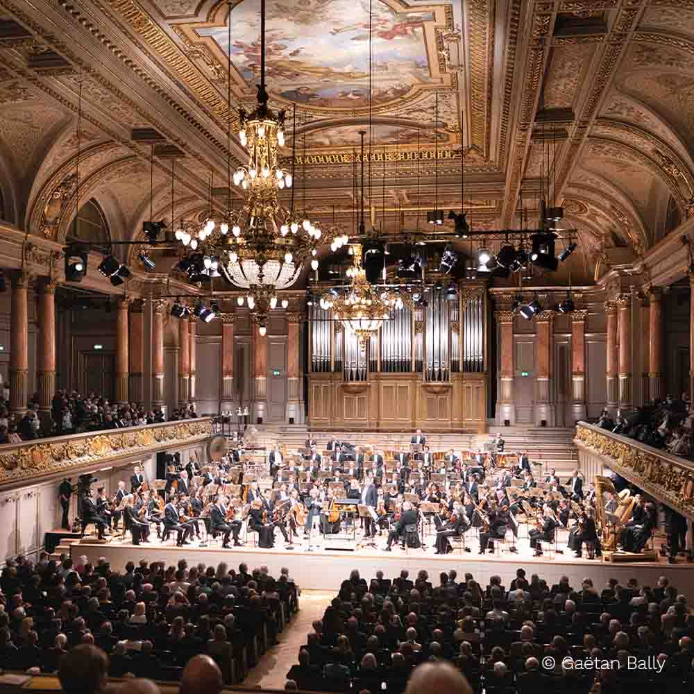 An orchestra plays on a choir stage in an older building