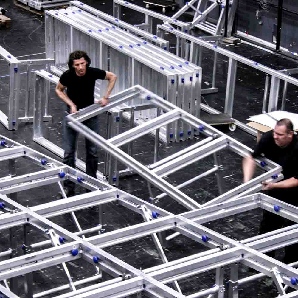 Several people setting up a mobile stage
